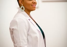 Portrait of a smiling female doctor in a white coat, exuding professionalism and confidence.