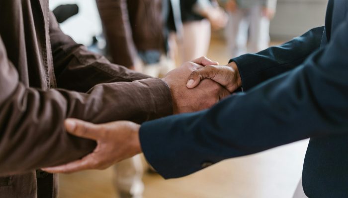 Close-up of two businesspeople shaking hands, symbolizing agreement and partnership.